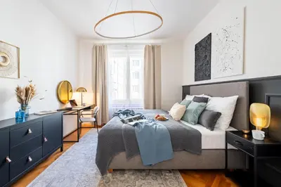 a bedroom with a bed and a desk in it at Prague Days - Apartment with Balcony & Garage near Vltava River in New Town in Prague