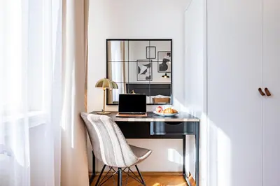 a desk with a laptop and a chair at Prague Days - Apartment with Balcony & Garage near Vltava River in New Town in Prague