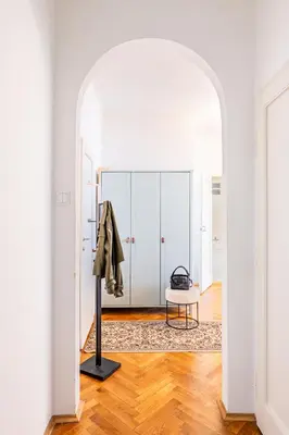 a hallway with white cabinets and a table in a room at Prague Days - Apartment with Balcony & Garage near Vltava River in New Town in Prague