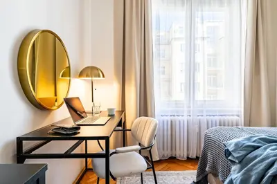 a bedroom with a desk with a laptop and a mirror at Prague Days - Apartment with Balcony & Garage near Vltava River in New Town in Prague
