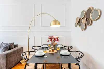 a dining room with a black table and chairs at Prague Days - Apartment with Balcony & Garage near Vltava River in New Town in Prague
