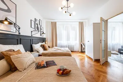 a living room with two beds and a bowl of fruit at Prague Days - Apartment with Balcony & Garage near Vltava River in New Town in Prague