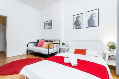 a white bedroom with a red blanket on a bed at 2BDR Old Town Square Apartments w Fast Wi-Fi in Prague