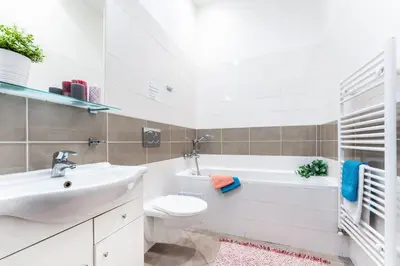a bathroom with a sink and a toilet and a bath tub at 2BDR Old Town Square Apartments w Fast Wi-Fi in Prague