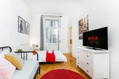 a white living room with a tv and a couch at 2BDR Old Town Square Apartments w Fast Wi-Fi in Prague