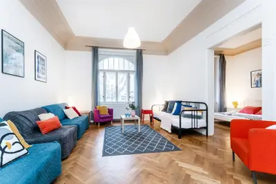 a living room with a blue couch and chairs at 2BDR Old Town Square Apartments w Fast Wi-Fi in Prague