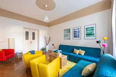a living room with a blue couch and yellow chairs at 2BDR Old Town Square Apartments w Fast Wi-Fi in Prague