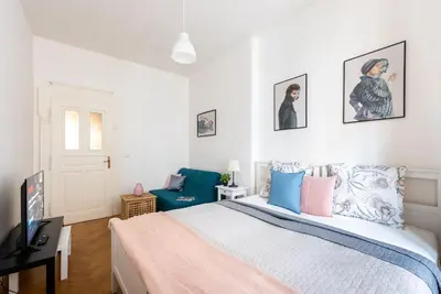a bedroom with a bed and a blue chair at 2BDR Old Town Square Apartments w Fast Wi-Fi in Prague