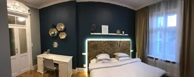 a bedroom with a bed and a table and a window at Holec Apartments in Prague