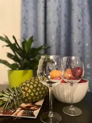 two wine glasses and a bowl of fruit on a table at Báječné ubytování ve vile s bazénem a terasou v praze in Prague