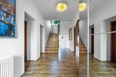 a hallway with wooden floors and white walls at Báječné ubytování ve vile s bazénem a terasou v praze in Prague