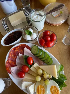 a plate of food with cheese and vegetables on a table at Apartment Garden in Prague