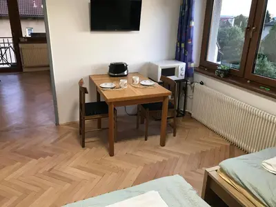 a dining room table with two chairs and a television at Apartment Garden in Prague