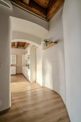 an empty room with wooden ceilings and wooden floors at Charles Bridge Prague Apartment in Prague