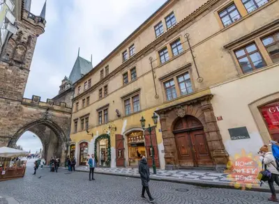 a group of people walking in a street next to a building at Charles Bridge Prague Apartment in Prague