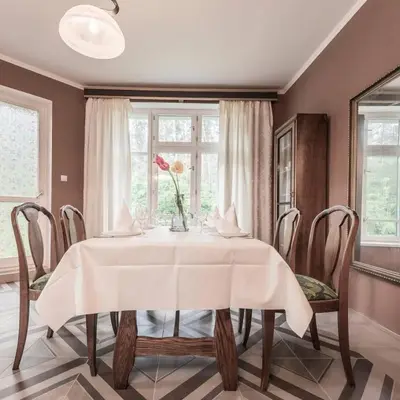a dining room with a table with a vase of flowers on it at Vila u Prahy,v prirode,jezero Lhota in Lhota