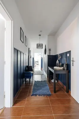 a living room with a table and a blue accent wall at Spacious flat & parking possibility, 3 stops to Wenceslav square in Prague