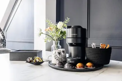 a table with a coffee maker and some cupcakes at Spacious flat & parking possibility, 3 stops to Wenceslav square in Prague