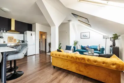 a living room with a yellow couch and a kitchen at Spacious flat & parking possibility, 3 stops to Wenceslav square in Prague