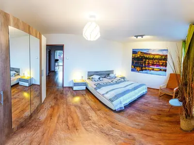 a bedroom with a bed and a painting on the wall at Apartment Pod Sychrovem in Prague