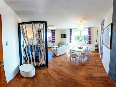 a living room with a mirror and a table at Apartment Pod Sychrovem in Prague