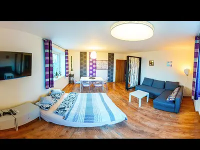 a large living room with a blue couch and a table at Apartment Pod Sychrovem in Prague