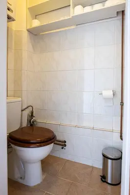 a bathroom with a toilet with a wooden toilet seat at Sunset Apartment Prague in Prague