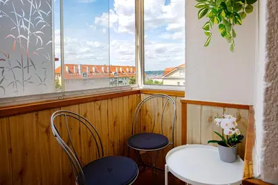 a table and two chairs in a room with a window at Sunset Apartment Prague in Prague