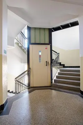 a hallway with stairs and a door in a building at Sunset Apartment Prague in Prague