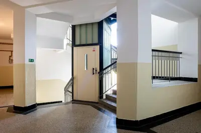a hallway with a door and stairs in a building at Sunset Apartment Prague in Prague