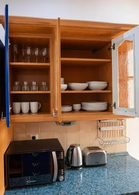 a kitchen counter with a microwave and bowls and plates at Sunset Apartment Prague in Prague