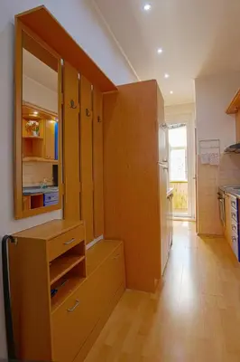 a kitchen with wooden cabinets and a refrigerator at Sunset Apartment Prague in Prague