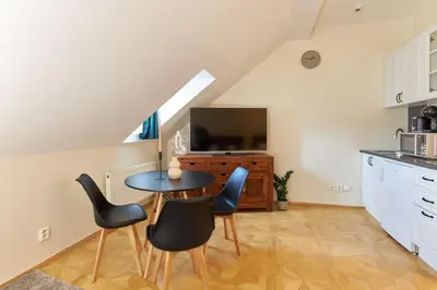 a kitchen with a table and chairs and a television at River View Residence by Charles Bridge in Prague