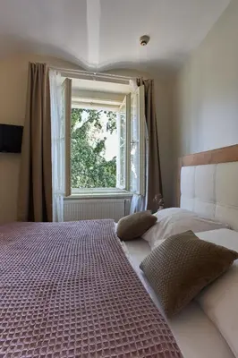 a bedroom with a large bed and a window at River View Residence by Charles Bridge in Prague