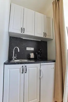 a kitchen with white cabinets and a sink at River View Residence by Charles Bridge in Prague