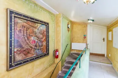a painting on the wall of a hallway with stairs at River View Residence by Charles Bridge in Prague