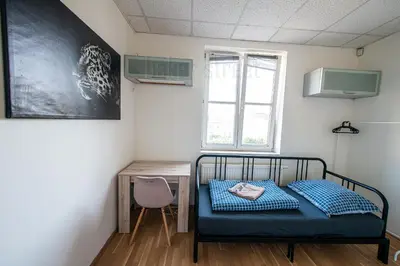 a small room with a bed and a desk at Snug room close to metro Palmovka in Prague