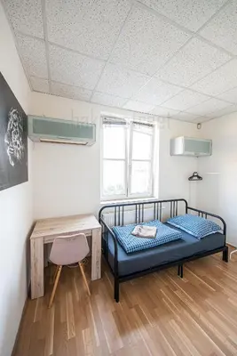 a bedroom with a bed and a desk and a table at Snug room close to metro Palmovka in Prague