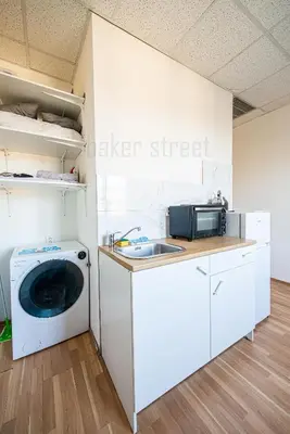 a kitchen with a washing machine and a sink at Snug room close to metro Palmovka in Prague