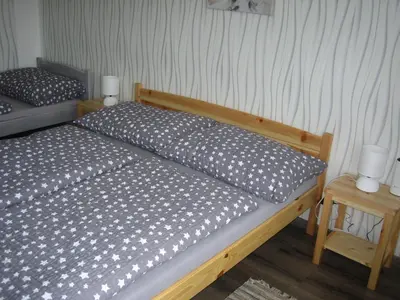 a bedroom with a bed and a table with two lamps at Apartmány Polepy in Polepy