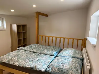 a bedroom with a bed with a wooden head board at Zahradní dům in Prague