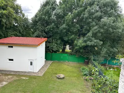 a backyard with a white house and a green fence at Zahradní dům in Prague
