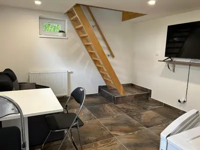 a room with a staircase and a table and chairs at Zahradní dům in Prague