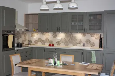 a kitchen with a wooden table and a kitchen with gray cabinets at Lovely And Freshly Renovated Apartment In Praha 10 in Prague