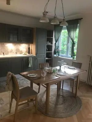 a kitchen with a wooden table with chairs and a dining room at Lovely And Freshly Renovated Apartment In Praha 10 in Prague