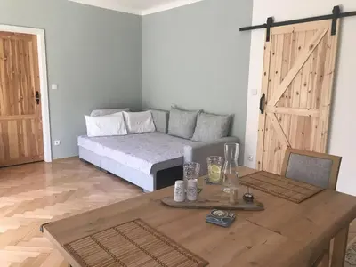 a room with a bed and a wooden table with a table sidx sidx at Lovely And Freshly Renovated Apartment In Praha 10 in Prague