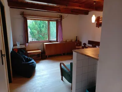 a living room with a kitchen and a dining room at Slapy chata Županovice in Županovice