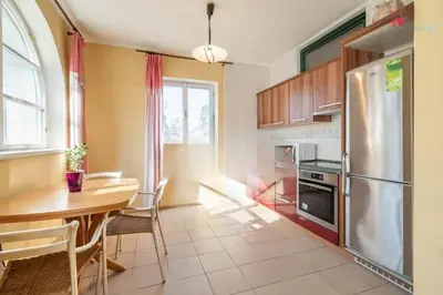 a kitchen with a table and a stainless steel refrigerator at Okouzlující vila u jezera Lhota in Lhota