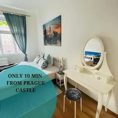 a bedroom with a bed and a desk and a mirror at TOP lokalita u Pražského hradu! in Prague