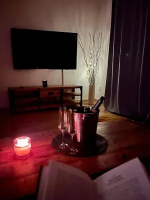 a table with a book and a candle and wine glasses at TOP lokalita u Pražského hradu! in Prague